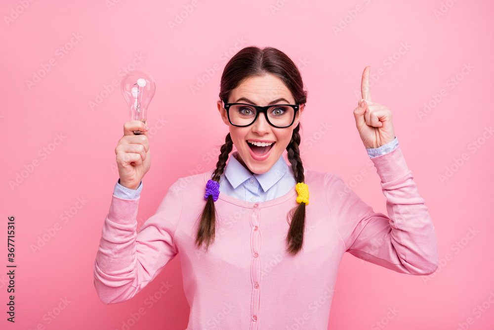 Close-up portrait of her she nice attractive cheerful cheery brown-haired teenage girl holding in hand lightlamp pointing forefinger up find decision isolated pink pastel color background - obrazy, fototapety, plakaty 