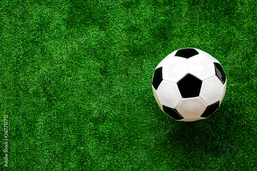 Football ball on green grass background top view copy space © 9dreamstudio