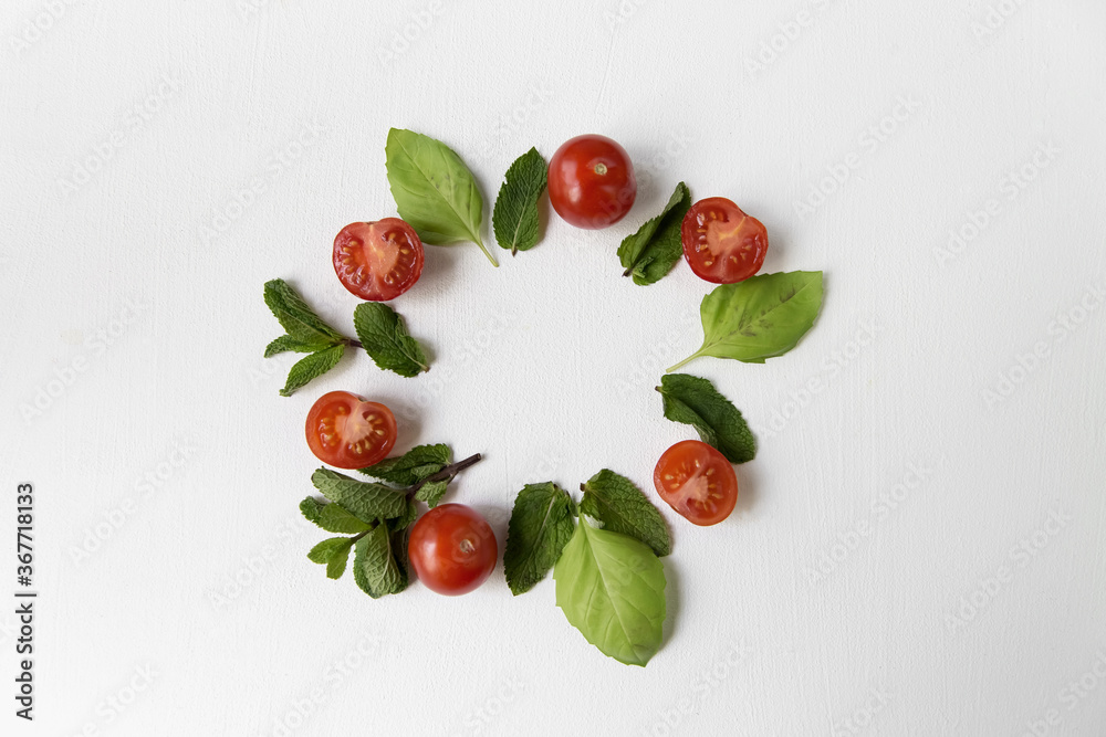 Composition of tomato, basil and mint with a place for an inscription in the center.
Composition of tomato, basil and mint with a place for an inscription in the center.