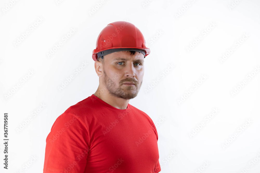 A man in a construction helmet and a red T-shirt. A man in a construction helmet and a red T-shirt.