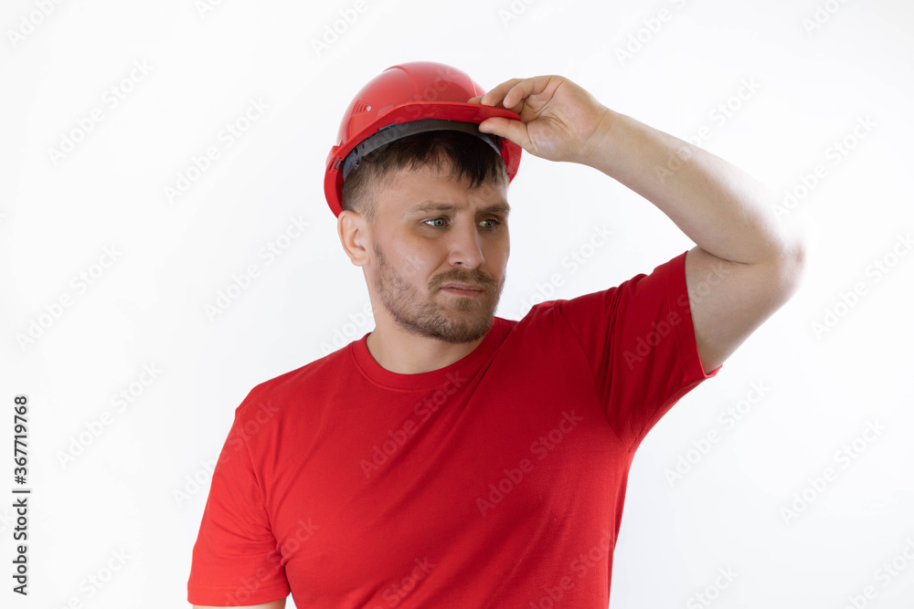 A man in a construction helmet and a red T-shirt. A man in a construction helmet and a red T-shirt.