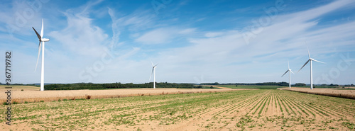 fields and wind turbine in the north of france under blue sky