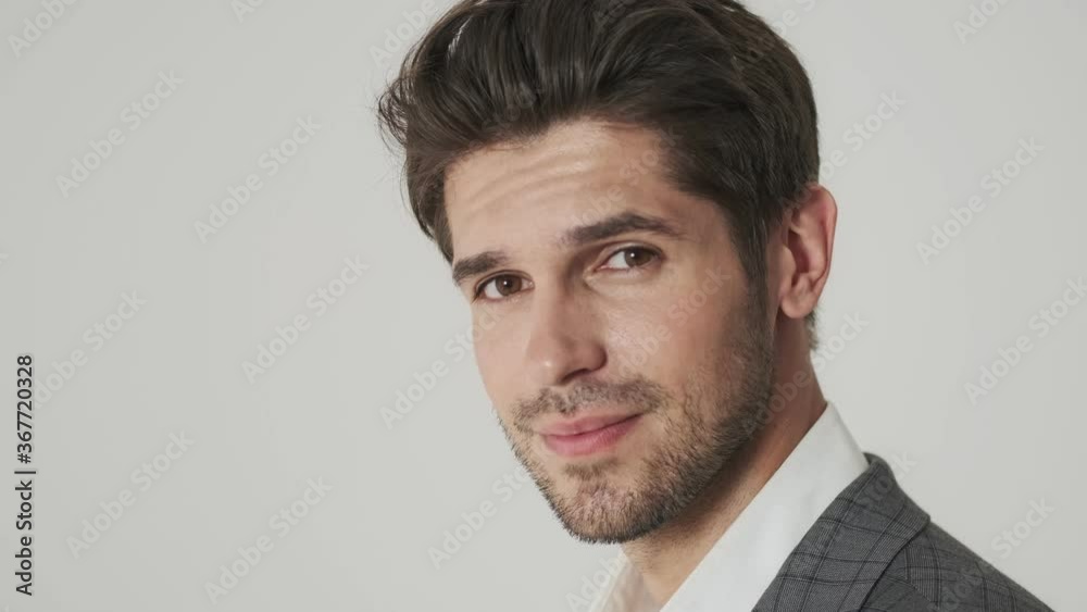 Positive pleased young business man isolated over white wall Positive pleased young business man isolated over white wall