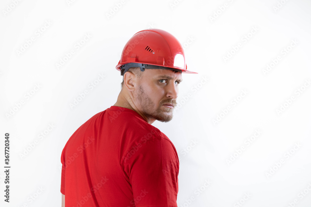 A man in a construction helmet and a red T-shirt.