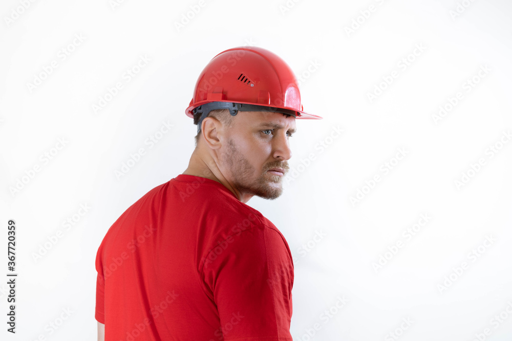 A man in a construction helmet and a red T-shirt. The man turned around.