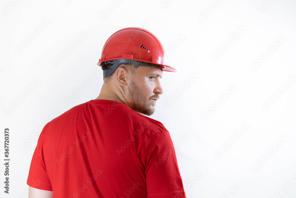 A man in a construction helmet and a red T-shirt.