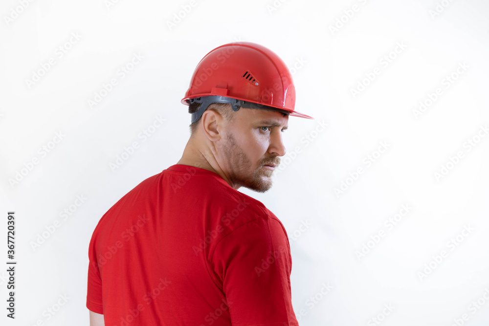 A man in a construction helmet and a red T-shirt. A man in a construction helmet and a red T-shirt.