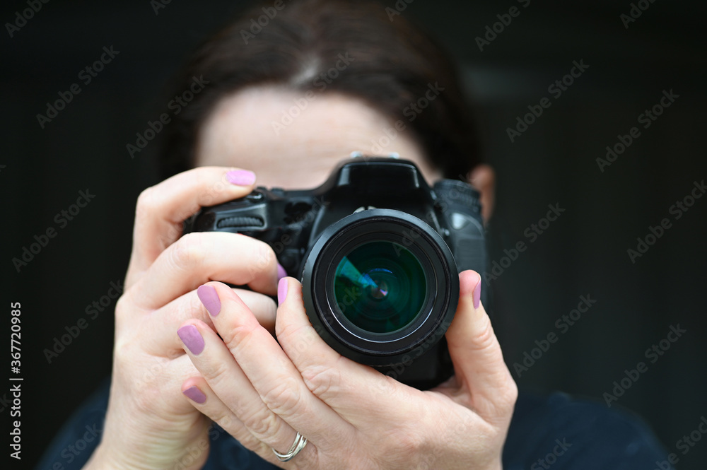 Woman photographer photographing with a camera