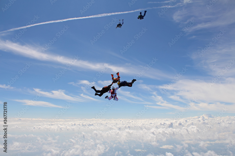 A group of skydivers is in the sky. A group of skydivers is in the sky.