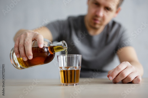 close up of male hands pouring alcohol into glass