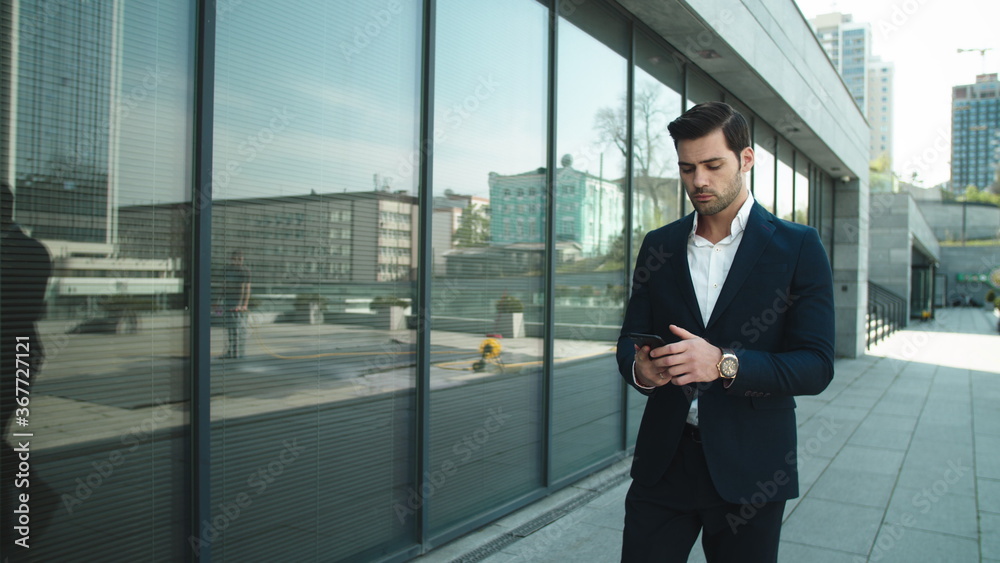 Closeup man arguing by phone. Businessman walking in slow motion at street Closeup man arguing by phone. Businessman walking in slow motion at street