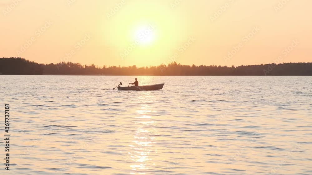 A man sailing at the sunset in a boat A man sailing at the sunset in a boat