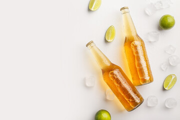 Freshen up and drink at summer. Bottles with beer in ice and pieces of lime on white background