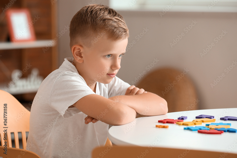 Little boy with autistic disorder doing puzzle at home Little boy with autistic disorder doing puzzle at home