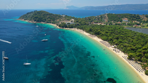 Aerial drone photo of beautiful popular organised sandy bay, turquoise beach and natural preserve lake with pine trees of Koukounaries, Skiathos island, Sporades, Greece