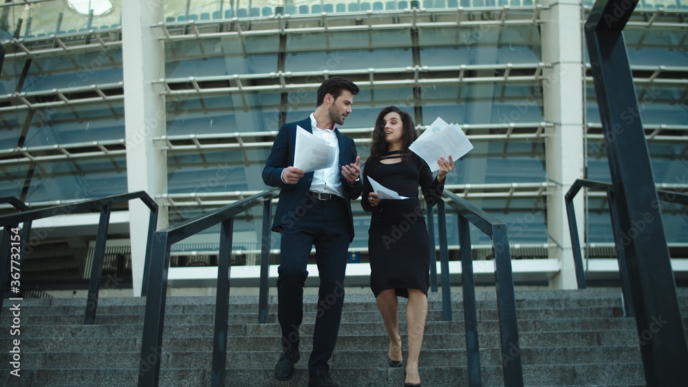 Couple walking with documents in slow motion. Couple discussing documents