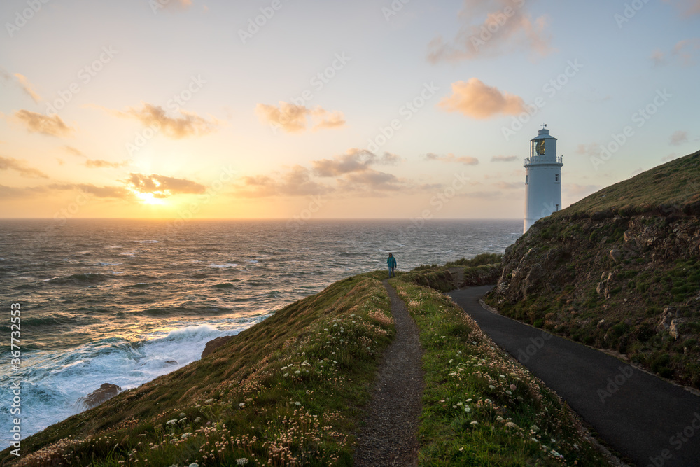 Trevose Head, Cornwall, UK. Lighthouse and hiker