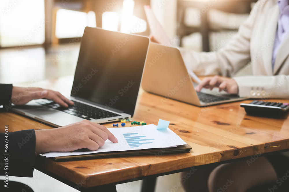 businessman pointing research data document and businesswoman using computer laptop for research or Marketing development in budget of company. businessman pointing research data document and businesswoman using computer laptop for research or Marketing development in budget of company.