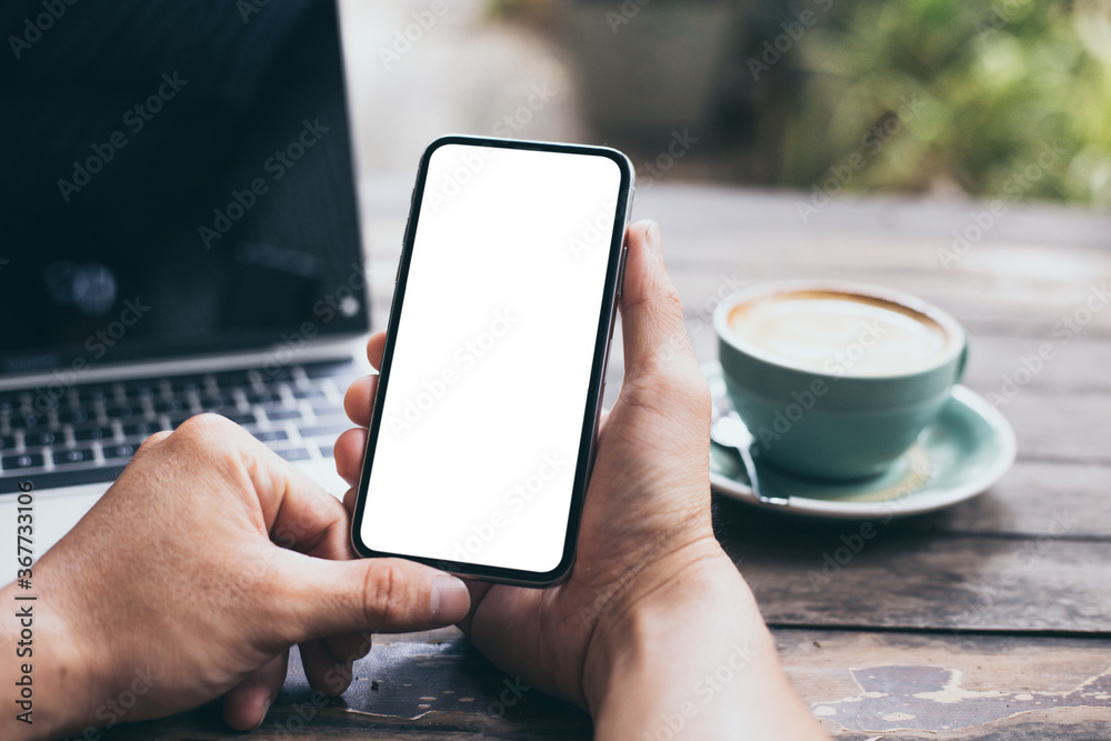 cell phone mockup image blank white screen.man hand holding texting using mobile on desk at coffee shop.background empty space for advertise.work people contact marketing business,technology