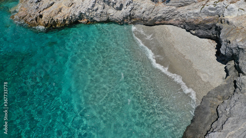 Aerial drone photo of secluded turquoise paradise island rocky cove covered up with pine trees