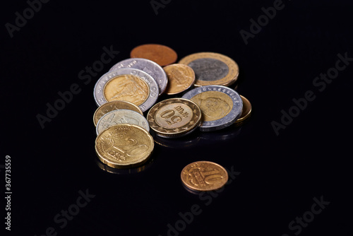coins of different countries, on black glass