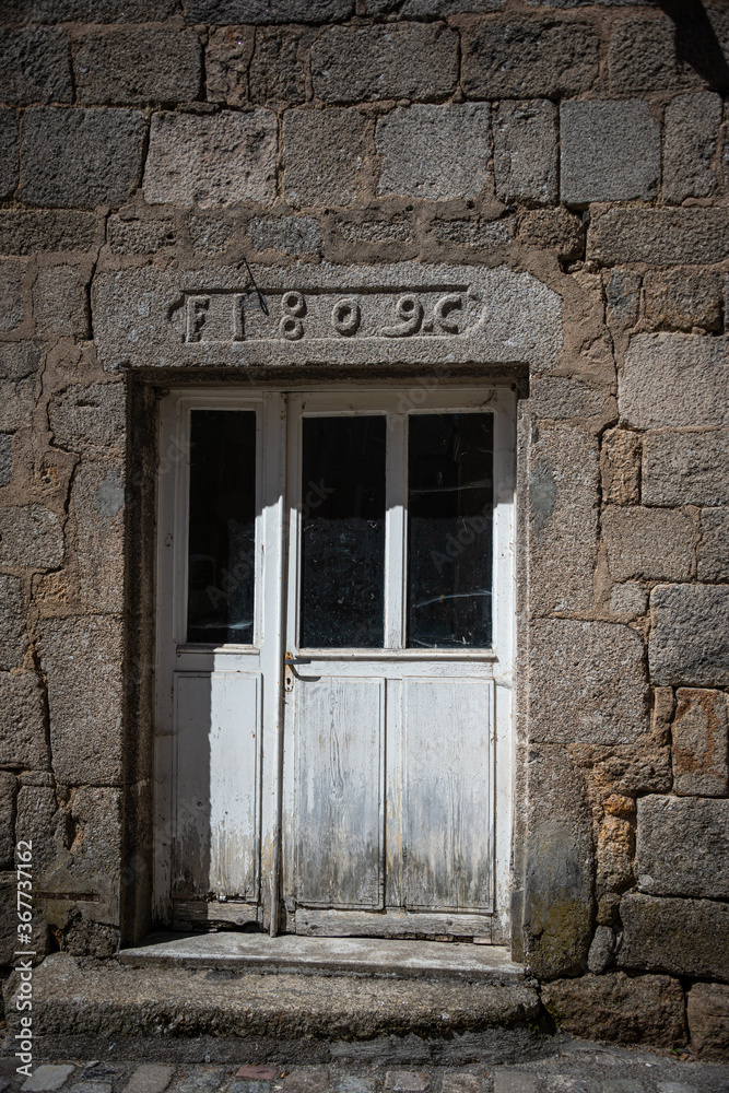 Stone cross and Flowers ,in the medieval town of Malzieu , lozere France .a stage in the way of compostelle a long distance walk . Stone cross and Flowers ,in the medieval town of Malzieu , lozere France .a stage in the way of compostelle a long distance walk .
