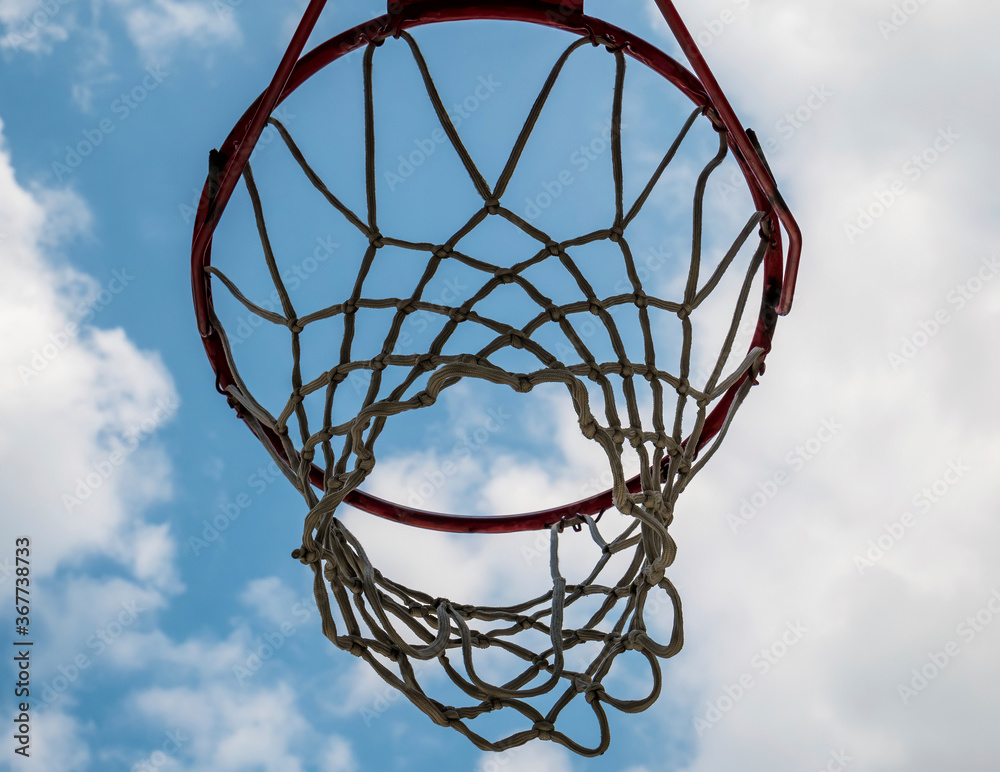 Close up with a basketball hoop against blue and cloudy sky. Close up with a basketball hoop against blue and cloudy sky.