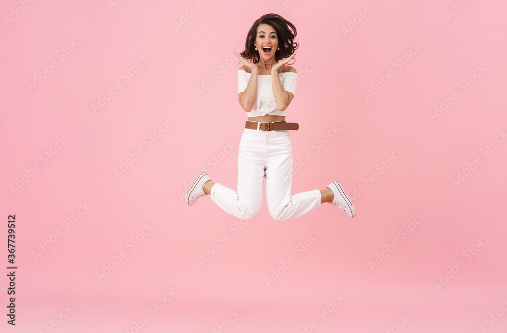 Image of delighted brunette woman expressing surprise while jumping