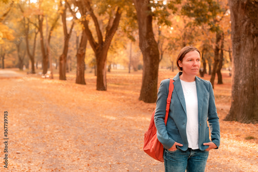 Portrait of businesswoman in autumn park, standing on footpath Portrait of businesswoman in autumn park, standing on footpath