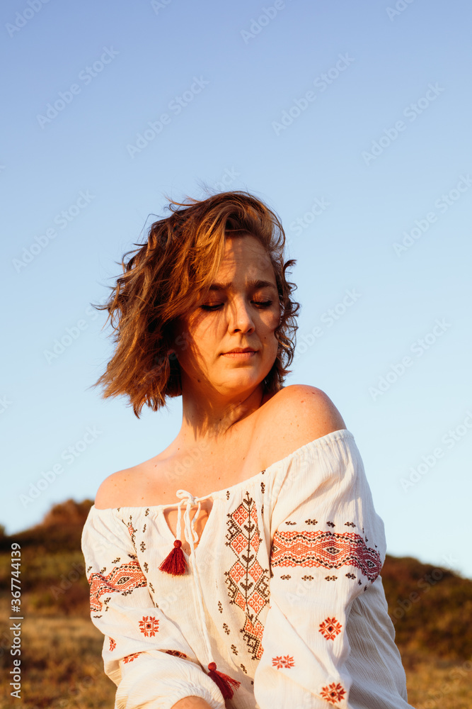 A natural and confident young woman in a meadow. A relaxation time in outdoors in the country side. A natural and confident young woman in a meadow. A relaxation time in outdoors in the country side.