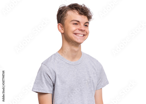 Portrait of smiling teen boy in gray t-shirt. Photo of adorable young happy boy looking away, isolated on white background.
