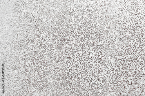 Cracked surface texture. Many small cracks on white paint. Old metal wall. Perfect for background and design.