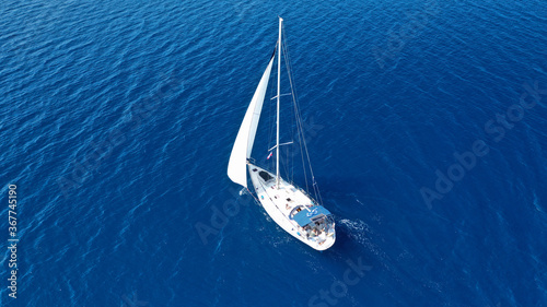 Aerial drone photo of beautiful sail boat with white sails, sailing open ocean deep blue Mediterranean sea © aerial-drone