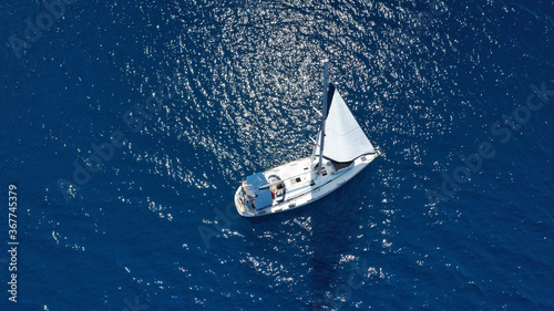 Aerial drone photo of beautiful sail boat with white sails, sailing open ocean deep blue Mediterranean sea © aerial-drone