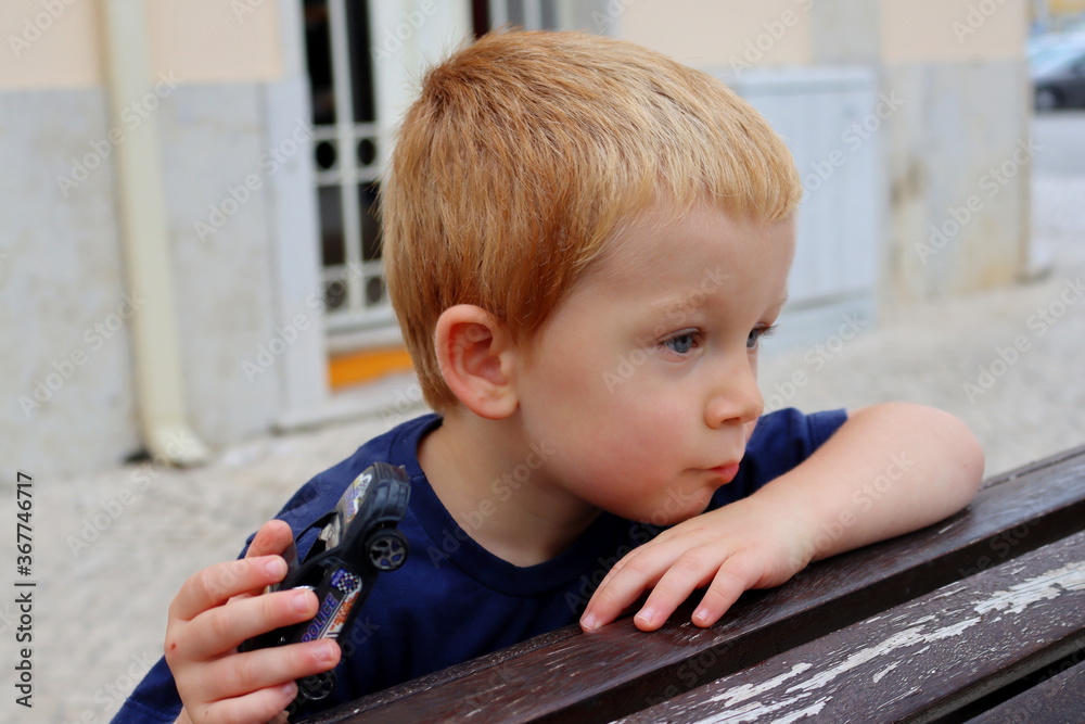 Portrait of a charming blond boy. A three-year-old boy leans on his hand and looks into the distance. Serious child. Portrait of a charming blond boy. A three-year-old boy leans on his hand and looks into the distance. Serious child.