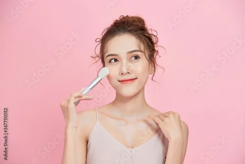 Obraz Attractive girl doing makeup, applying roygemon face. Makeup, fashion, cosmetics.