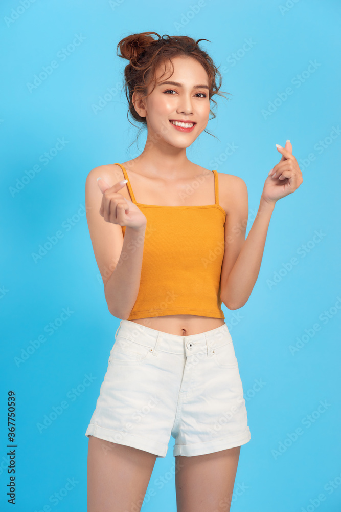 Cheerful curly lady in summer outfit sincerely laughs on blue background Cheerful curly lady in summer outfit sincerely laughs on blue background