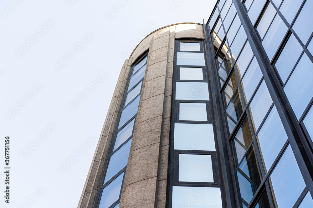 Fachada de edificio de oficinas con el reflejo del cielo azul durante el dia