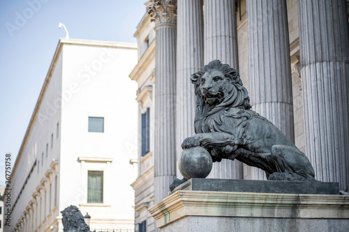 Estatua de un león de cobre sosteniendo una bola