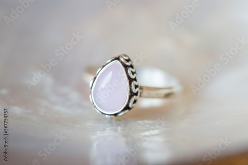 Elegant silver ring with rose quartz gemstone on rocky background