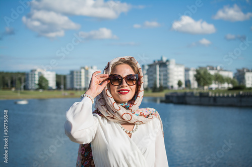 elegant portrait of young woman in headscarf and long white dress