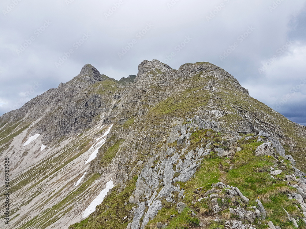 Eine schöne und gefährliche Gratwanderung in den Bergen (Alpen) mit vielen Gipfel