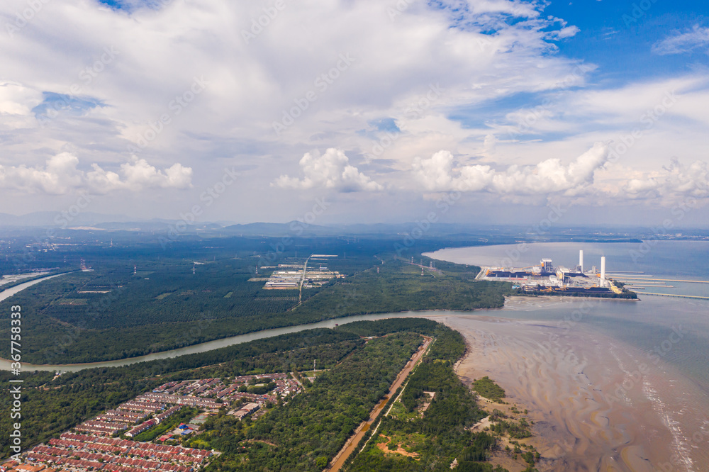 An aerial view of the dock of a Coal Power Plant at the Malaysia west coast. Two coal cargo ship at the dock to supply coal to the plant. At the polluted west coast of strait of Malacca. 