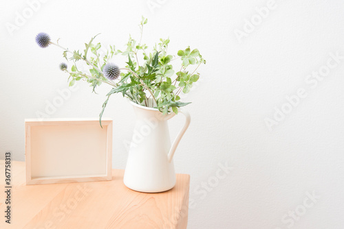 観葉植物と木製デスクとフレーム　明るい　爽やか　イメージ写真　インテリア　部屋　植物　花瓶　余白　ホワイトスペース　文字スペース　コピースペース　朝　昼