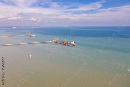 An aerial view of the dock of a Coal Power Plant at the Malaysia west coast. Two coal cargo ship at the dock to supply coal to the plant. At the polluted west coast of strait of Malacca.  © Holger