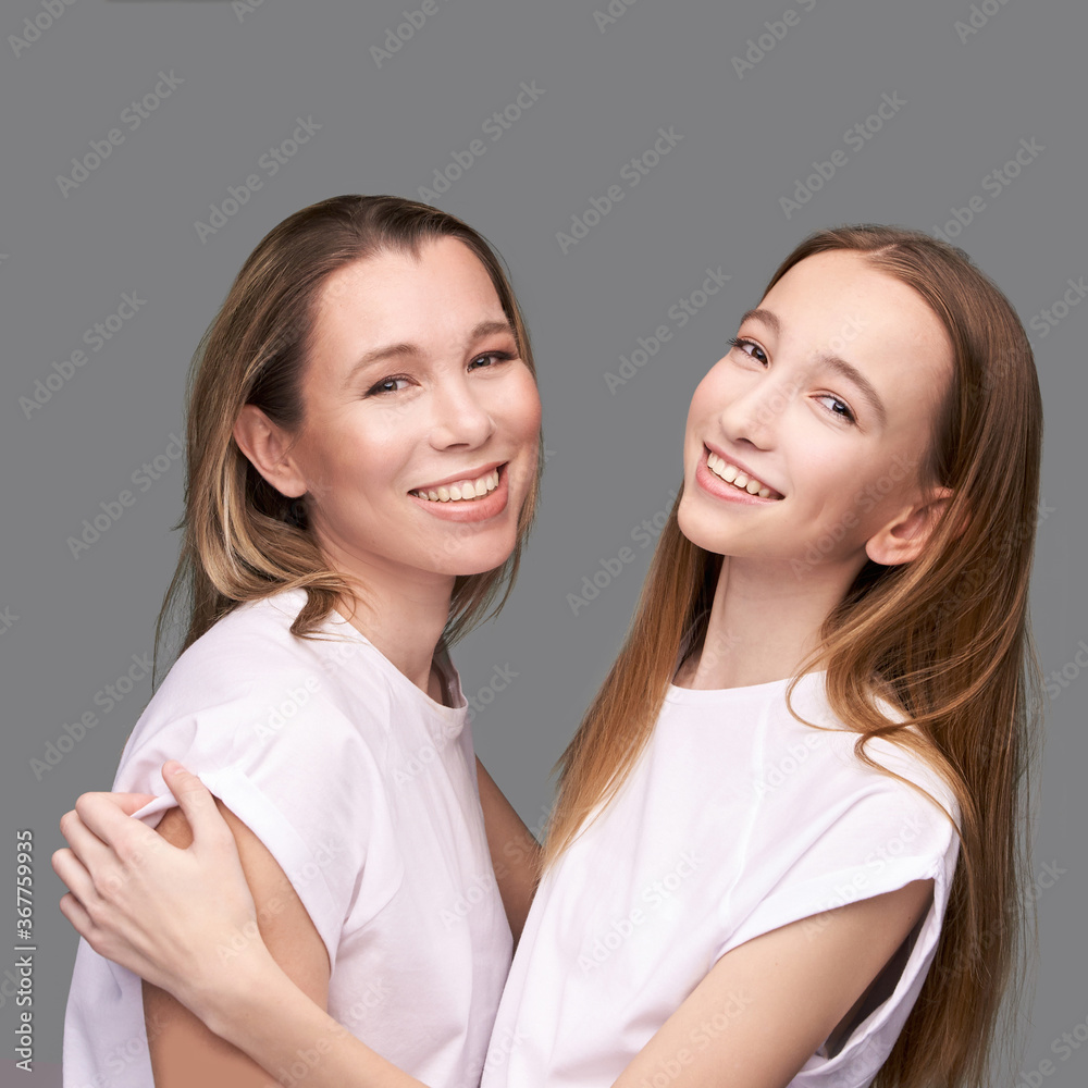 Elder mother and teenager daughter hug. Happy family portrait. Similar smile. Next generation love. Single mom. Mature parent. Smiling people group. Attractive posing together. Two hand connection Elder mother and teenager daughter hug. Happy family portrait. Similar smile. Next generation love. Single mom. Mature parent. Smiling people group. Attractive posing together. Two hand connection