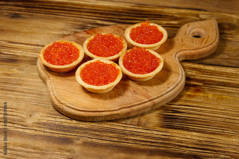 Tartlets with red caviar on a wooden table Tartlets with red caviar on a wooden table