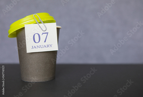 Coffee paper cup with calendar dates for January 07, Winter season. Time for relaxing breaks and vacations.