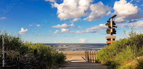 View of Jurmala coast with sea and pillar with direction signs.