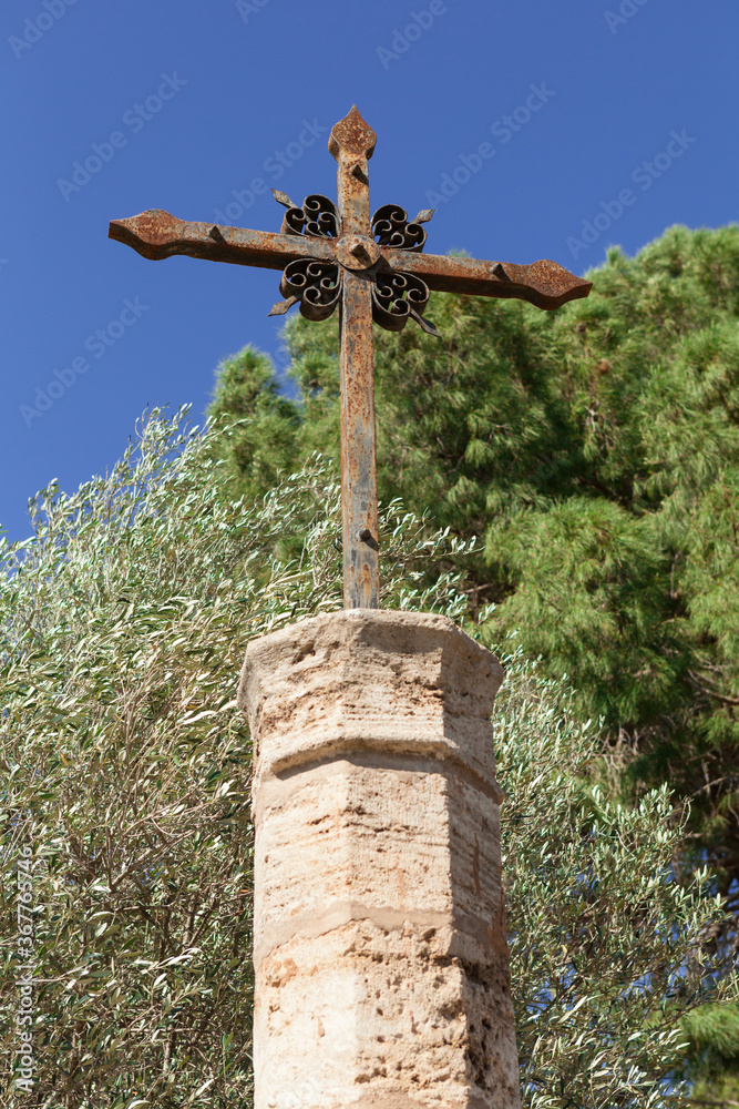 Obraz premium Stone pedestal with a crucifix in an old garden, Valencia, Spain.